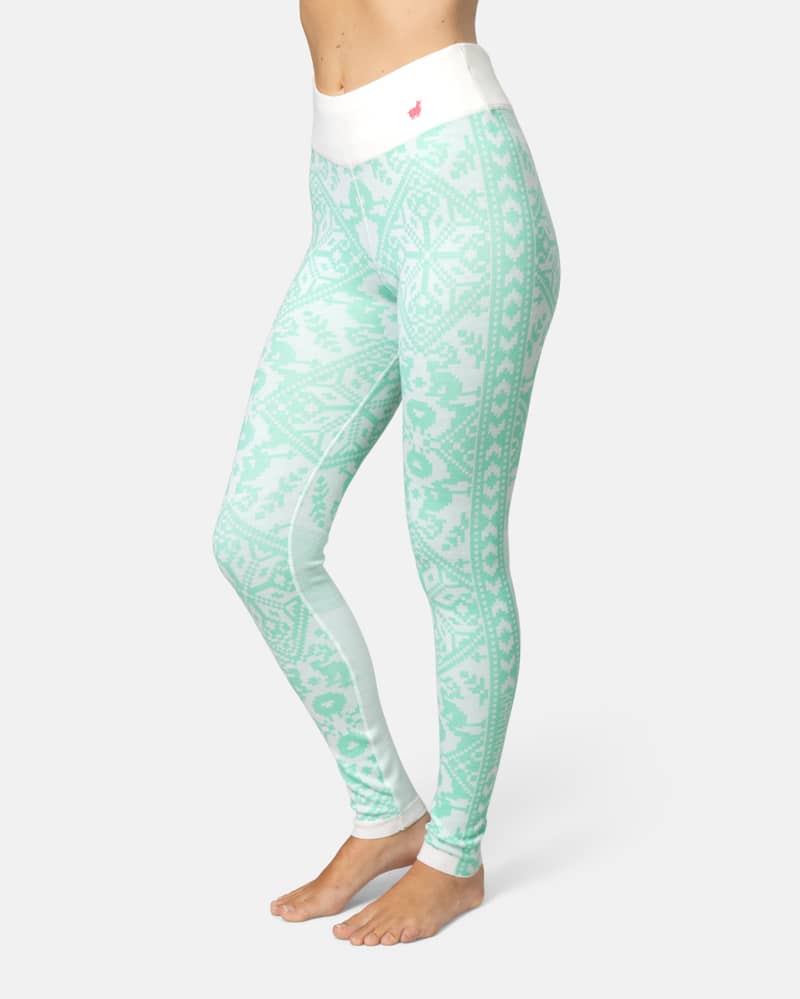 Side view of a woman in mint green Kari Traa Saga Base Layer Pants, showing the Scandinavian-inspired knit pattern.