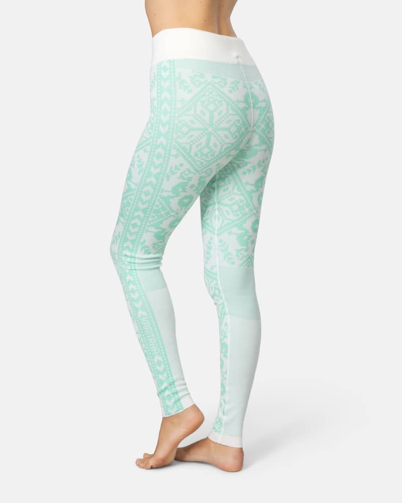 Back view of a woman in mint green Kari Traa Saga Base Layer Pants, highlighting the slim, high-waist fit.