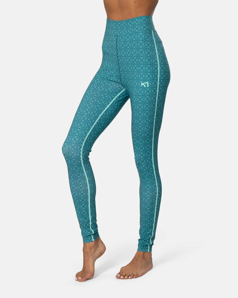 Side view of a woman wearing teal Kari Traa Fryd High Waist Pants, showing the body-hugging slim fit.