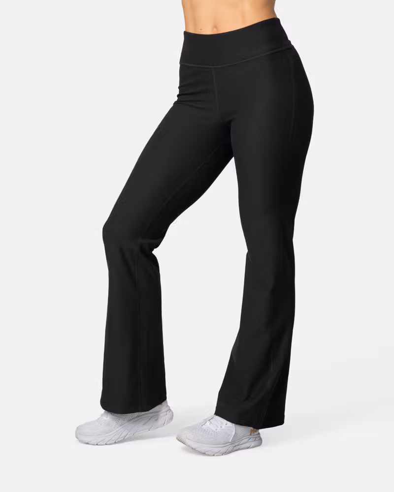 Woman wearing black Kari Traa Nina Flare Tights, perfect for transitioning from the gym to lounging with a stylish flare.