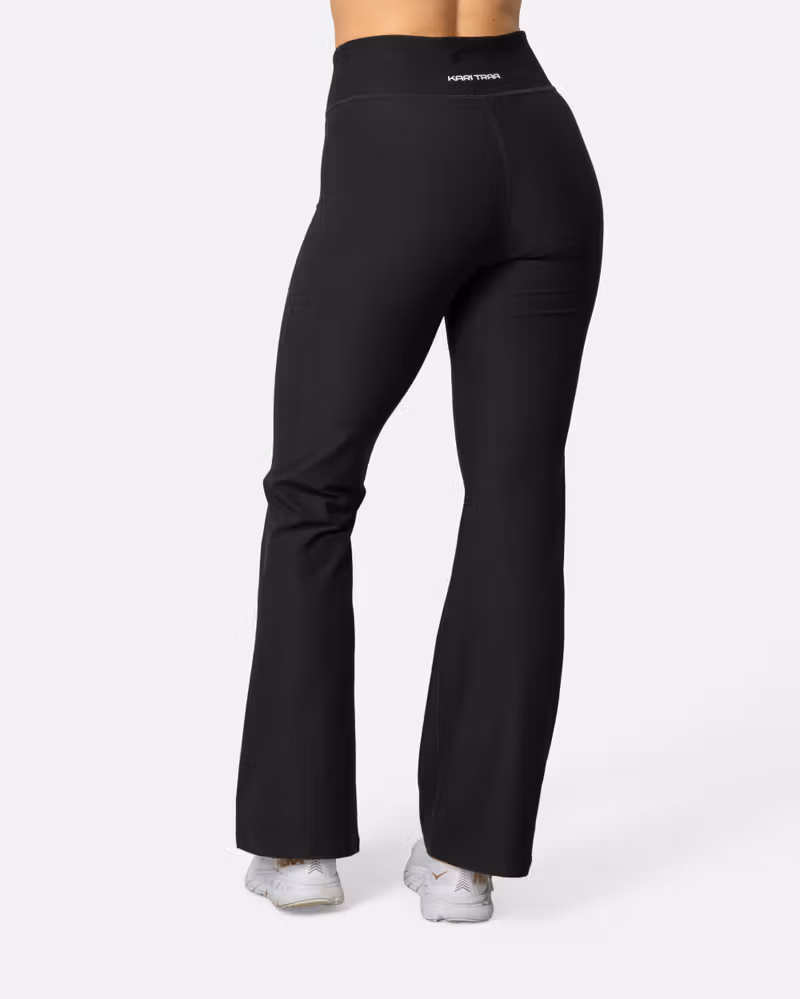 Back view of a woman in black Kari Traa Nina Flare Tights, showcasing the flattering slim fit and flared leg design.