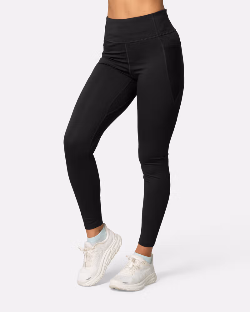 Woman wearing the black Kari Traa Nia Tights, showing their slim fit and 4-way stretch for high-impact workouts.