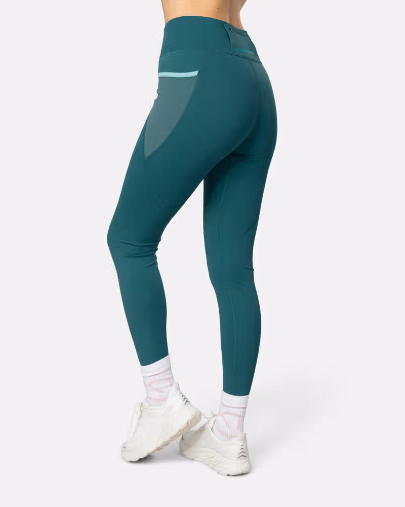 Side view of the blue lagoon Kari Traa Nia Tights, detailing the breathable mesh ventilation panels and pocket.
