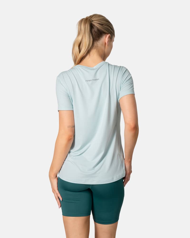 Back view of the aquatic Kari Traa Ava Tee, showing its curved hem and smooth flatlock seams for comfort.