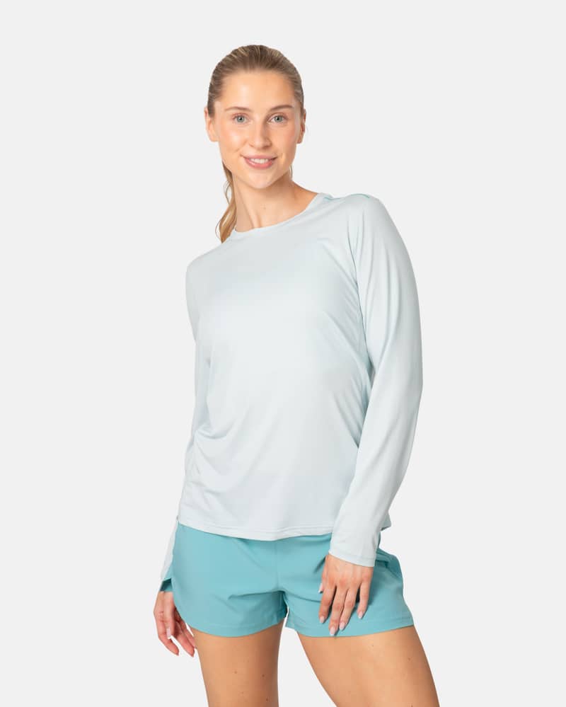 Woman wearing the aqua Kari Traa Ava Long Sleeve, a comfortable training shirt perfect for running or gym workouts.