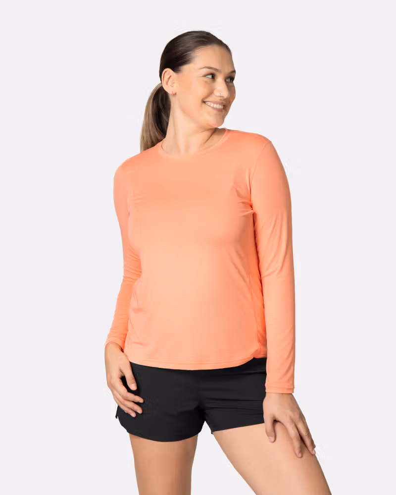 Woman wearing the peach blossom Kari Traa Ava Long Sleeve, a versatile training shirt with a comfortable fit for workouts.