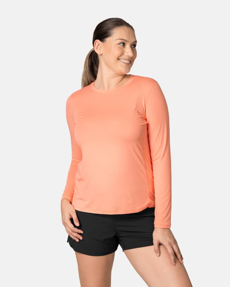 Woman wearing the peach blossom Kari Traa Ava Long Sleeve, a versatile training shirt with a comfortable fit for workouts.