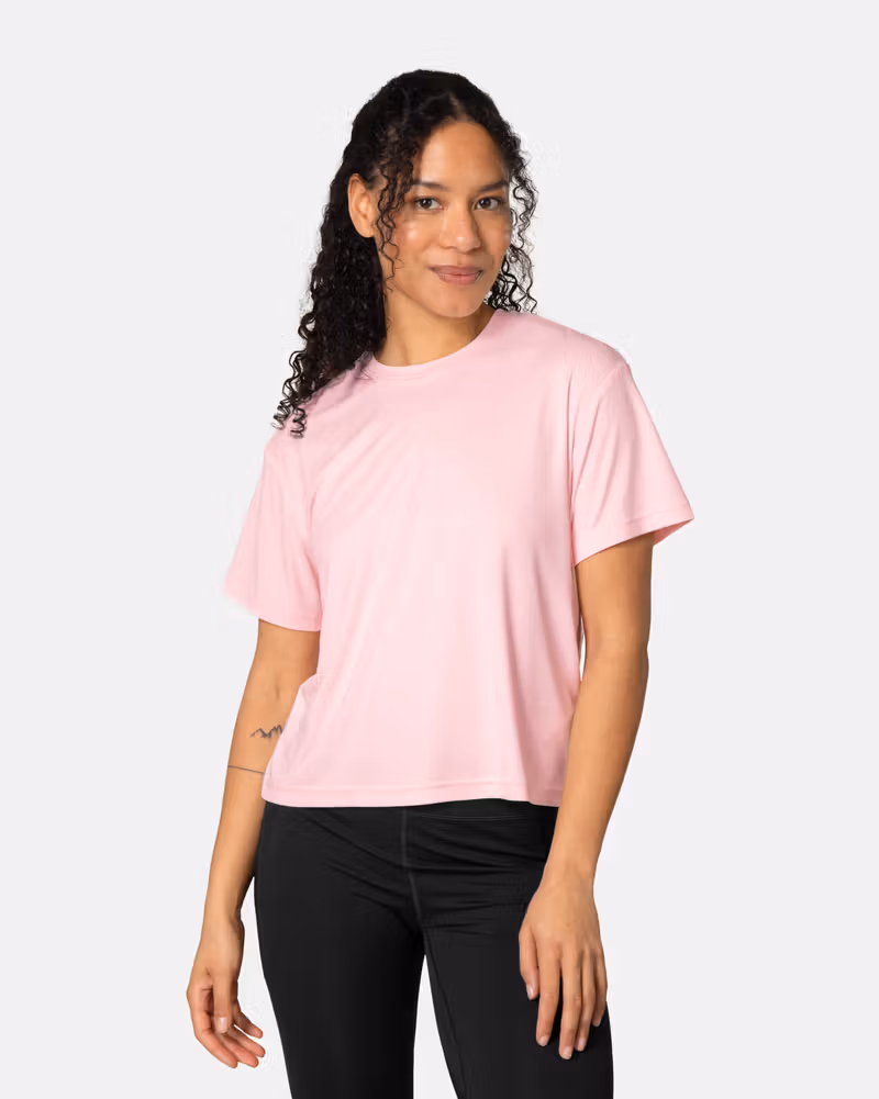 Woman wearing the Kari Traa Una Tee in pastel pink, a relaxed-fit shirt for workouts and warm weather adventures.