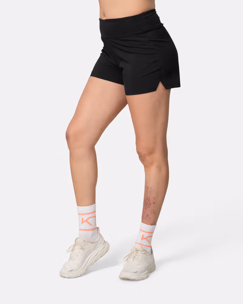 Woman wearing the black Kari Traa Ava Shorts, showing the comfortable fit and functional side split for running.