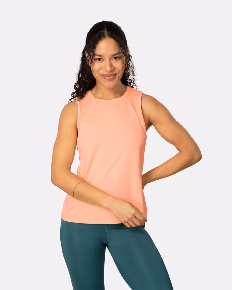 Woman wearing the peach blossom Kari Traa Ava Tanktop, showing its flattering fit and round neck for gym workouts.