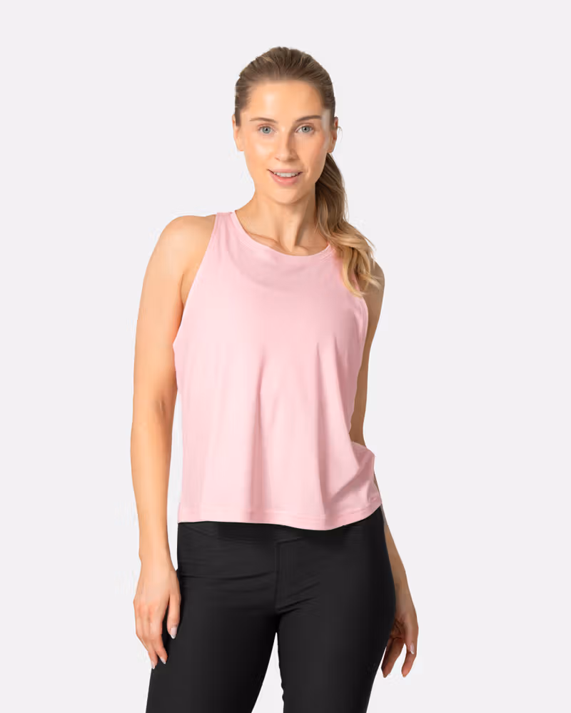 Woman wearing the Kari Traa Una Tanktop in pastel pink, a relaxed-fit top for warm weather adventures and workouts.