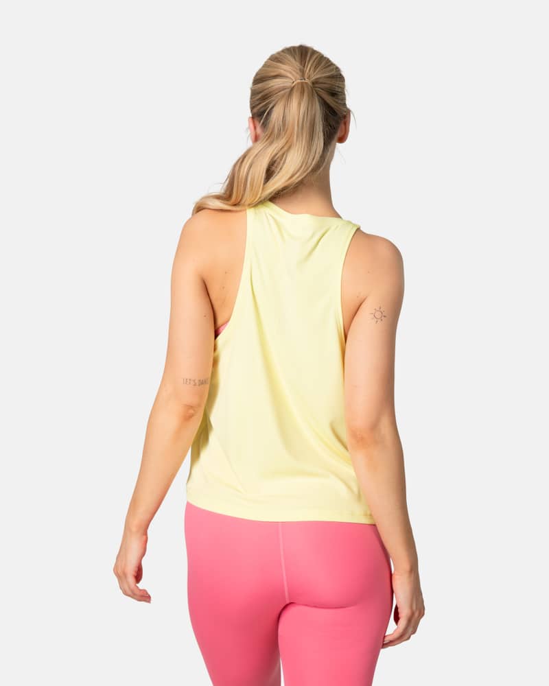 Back view of a woman in the yellow Kari Traa Una Tanktop, showing the functional racerback for freedom of movement.