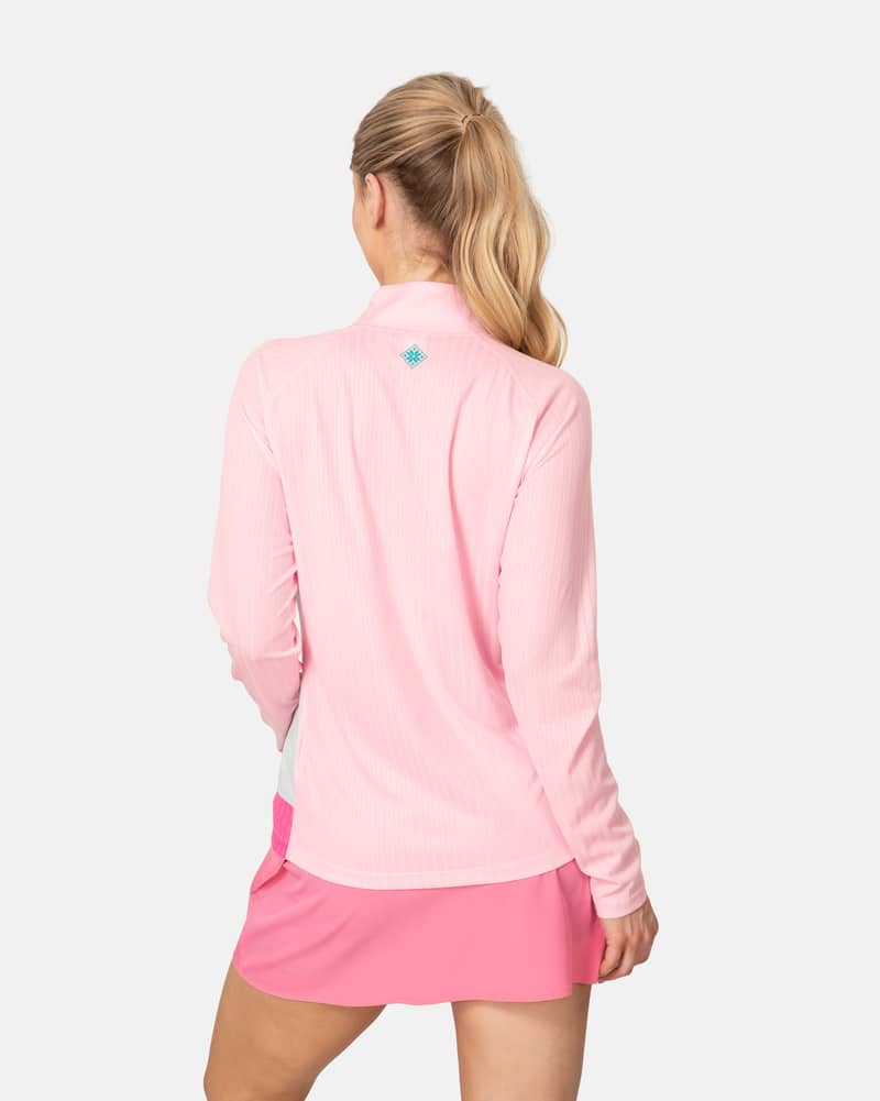 Back view of a woman wearing the pink Kari Traa Leah Half Zip base layer, showing the relaxed fit and logo detail.