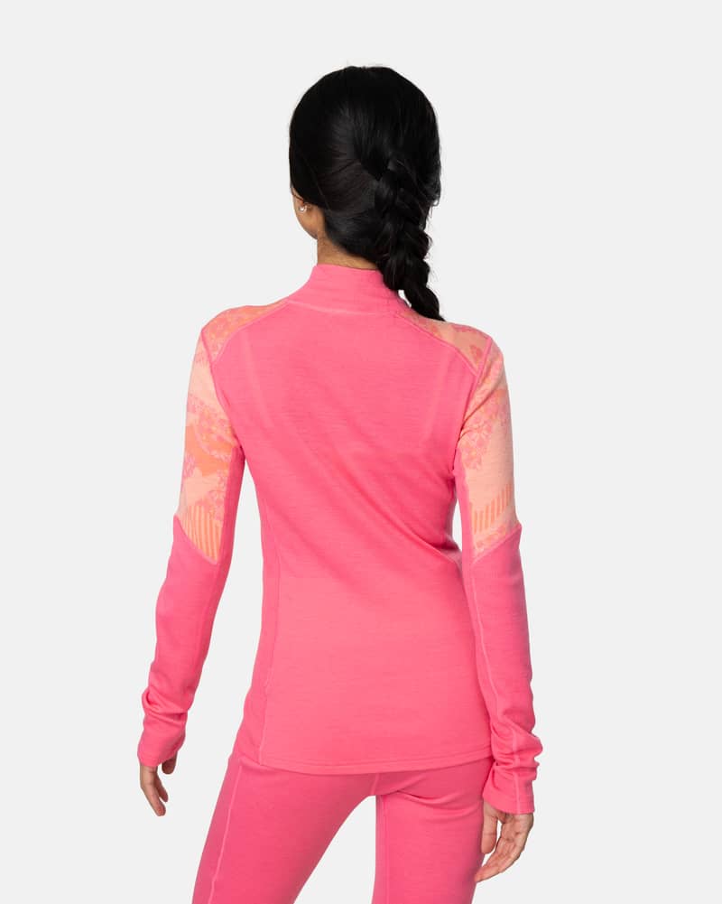 Back view of a woman in the bright pink Kari Traa Olea Half Zip, highlighting the jacquard knit back panel.