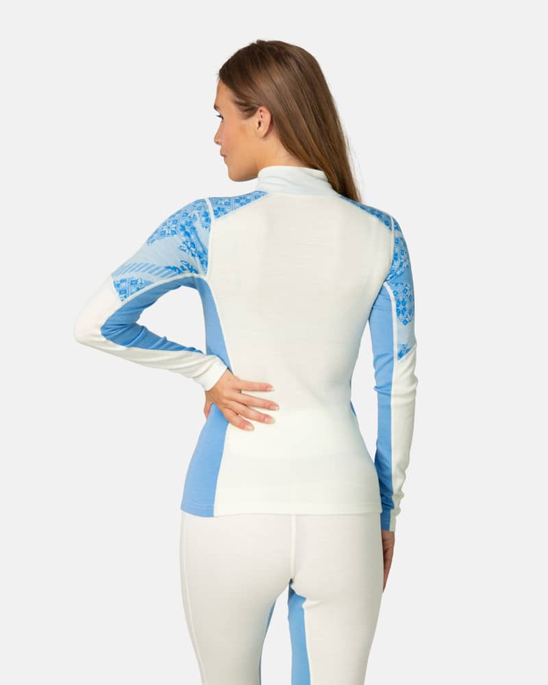 Back view of a woman in the light blue Kari Traa Olea Half Zip, highlighting the jacquard knit design.